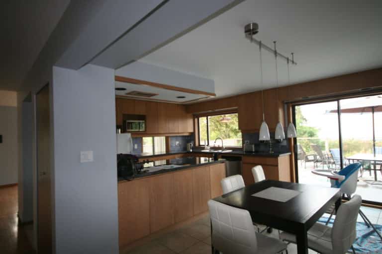 Balmoral kitchen before renovation, oak cabinets and a dark dining table beside sliding deck doors.