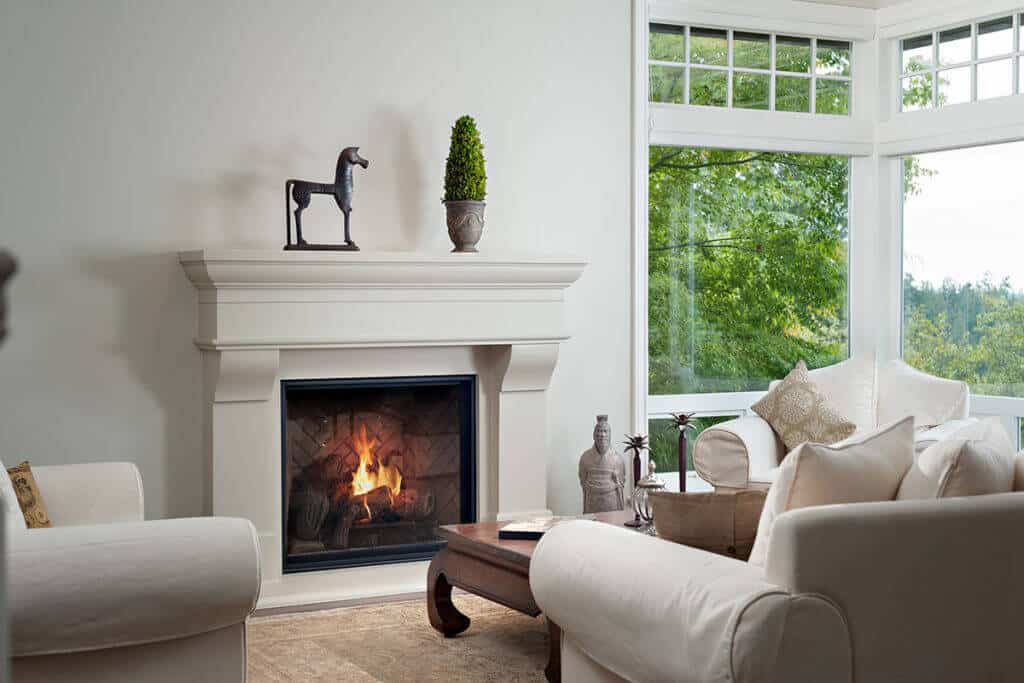 Modern Classic after renovation, a cast stone fireplace and bay window above cream sofas.