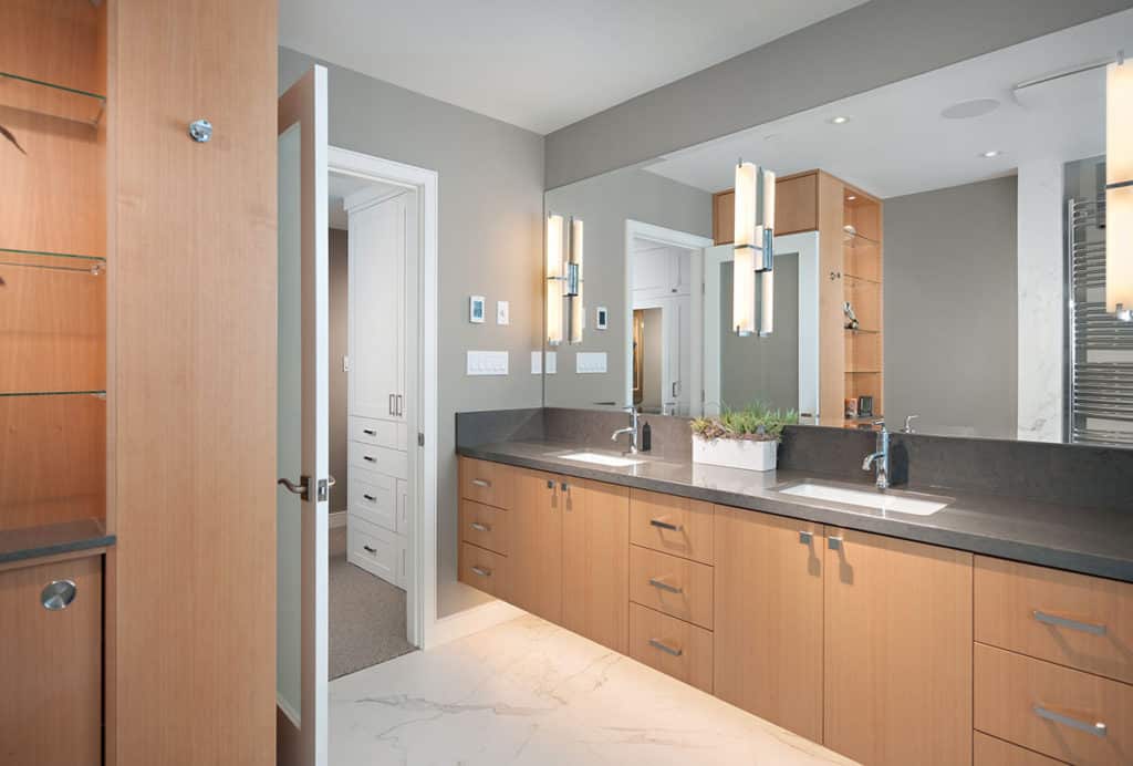 Sailor Retreat after renovation, maple cabinets and a dark stone counter with twin basins and tall mirrors.