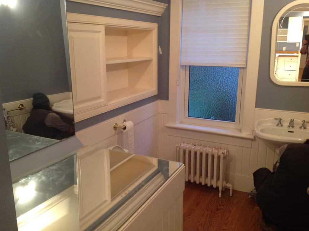 Queens before renovation, an old tub and pedestal basin beside a cast iron radiator.