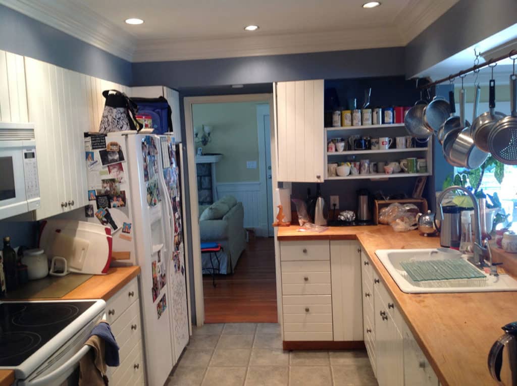 Queens before renovation, a narrow galley kitchen with wood counters and open shelving.
