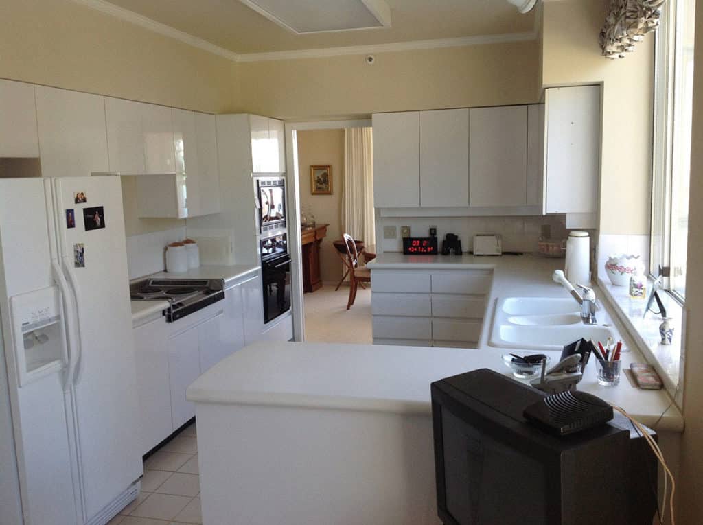 Sailor Retreat before renovation, white laminate cabinets and a peninsula in a closed kitchen.