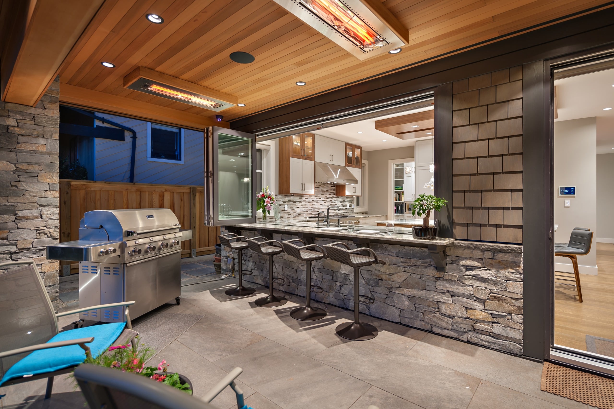 A covered outdoor kitchen and bar built by Shakespeare Homes