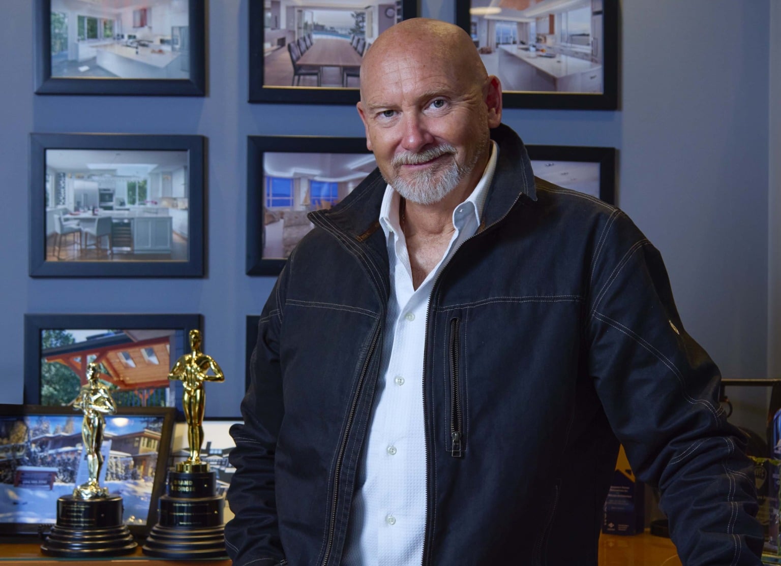 Mark Cooper with the Shakespeare Homes Georgie Awards and a wall of completed projects