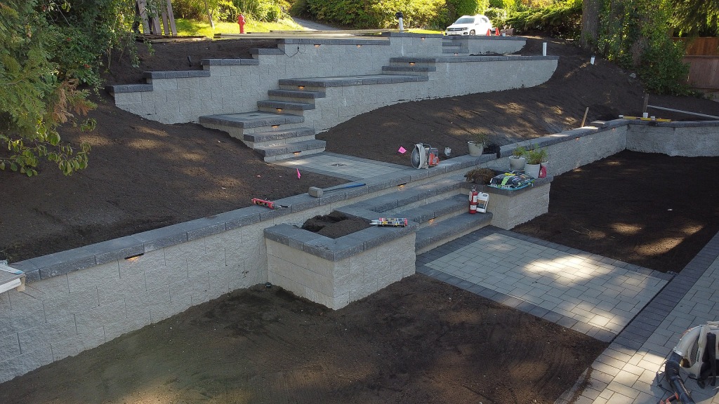 Terraced retaining walls and stone steps finished, ready for planting