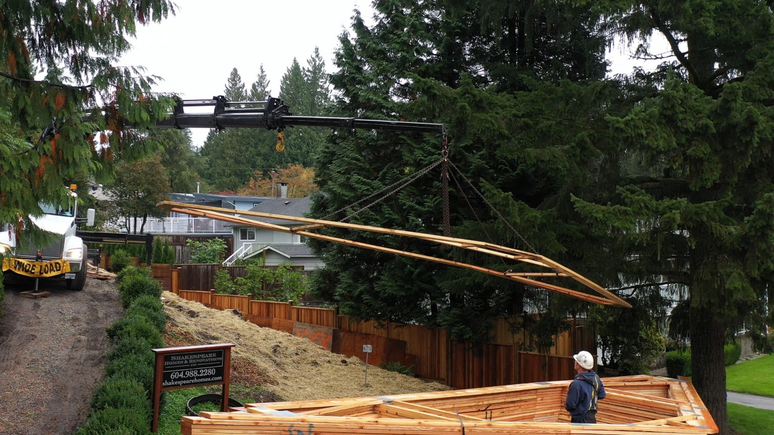 A boom truck lifting roof trusses onto a Shakespeare Homes build in North Vancouver